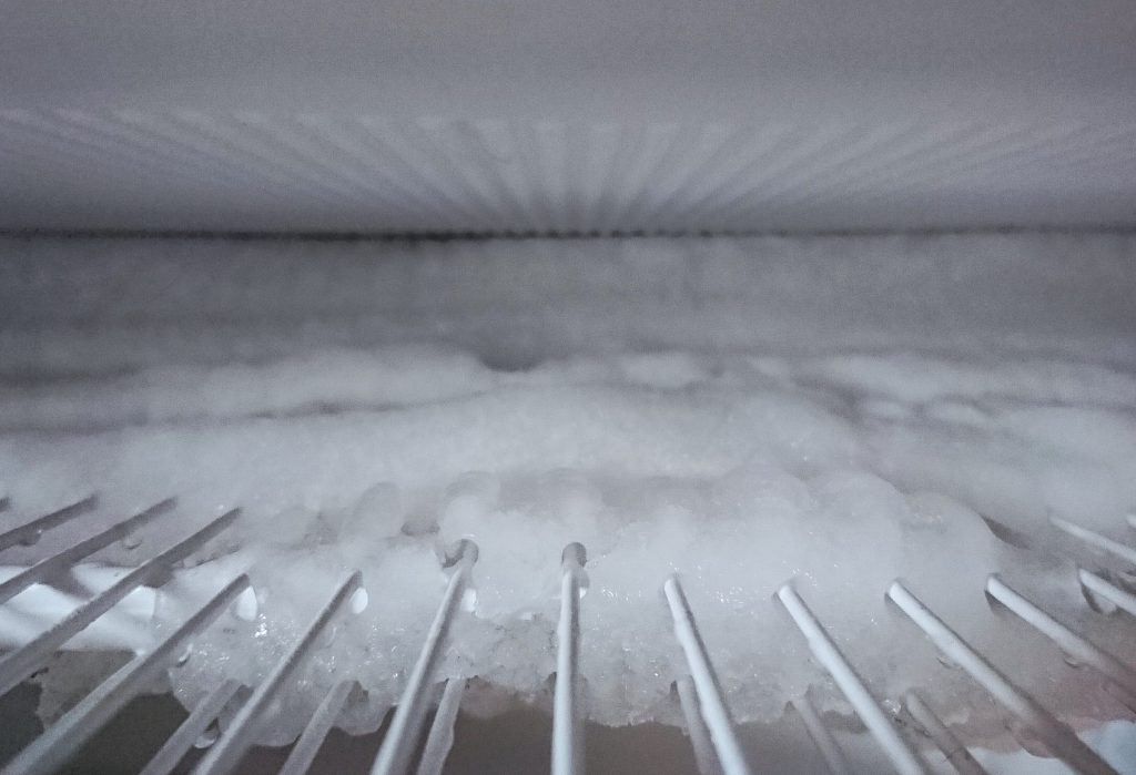 An evaporator grid under a sheet of frost, seen along the shelf.