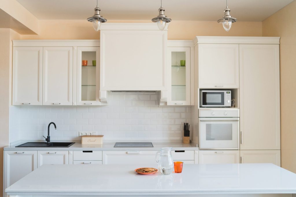 An oven in a bright kitchen with island cabinets.