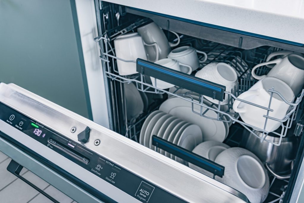 Clean dishes inside modern dishwasher machine.