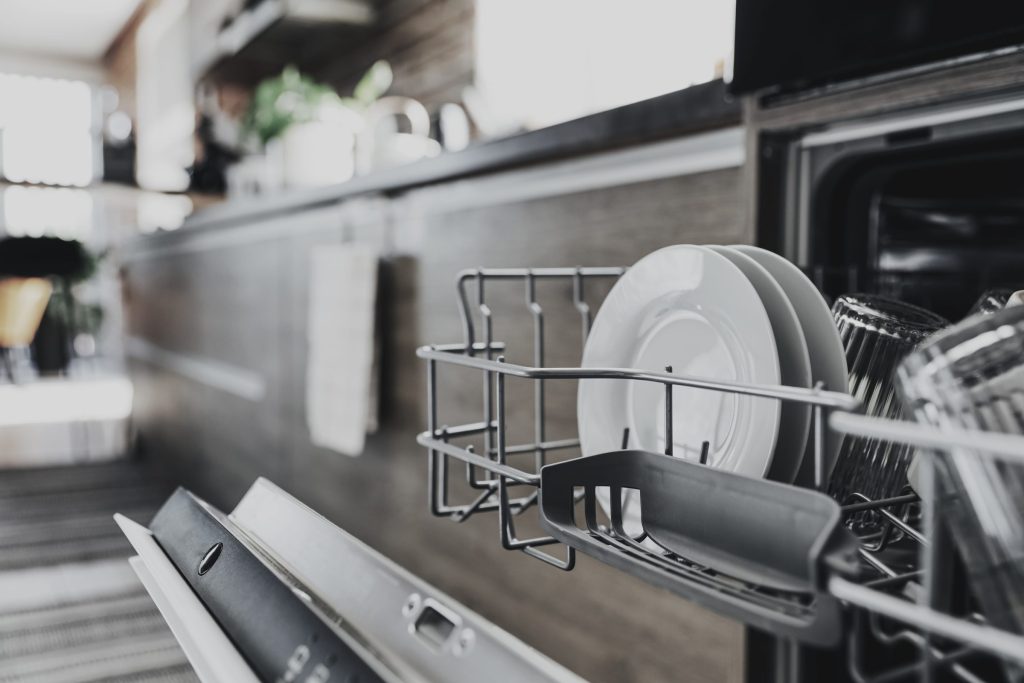 Clean dishes inside modern dishwasher.