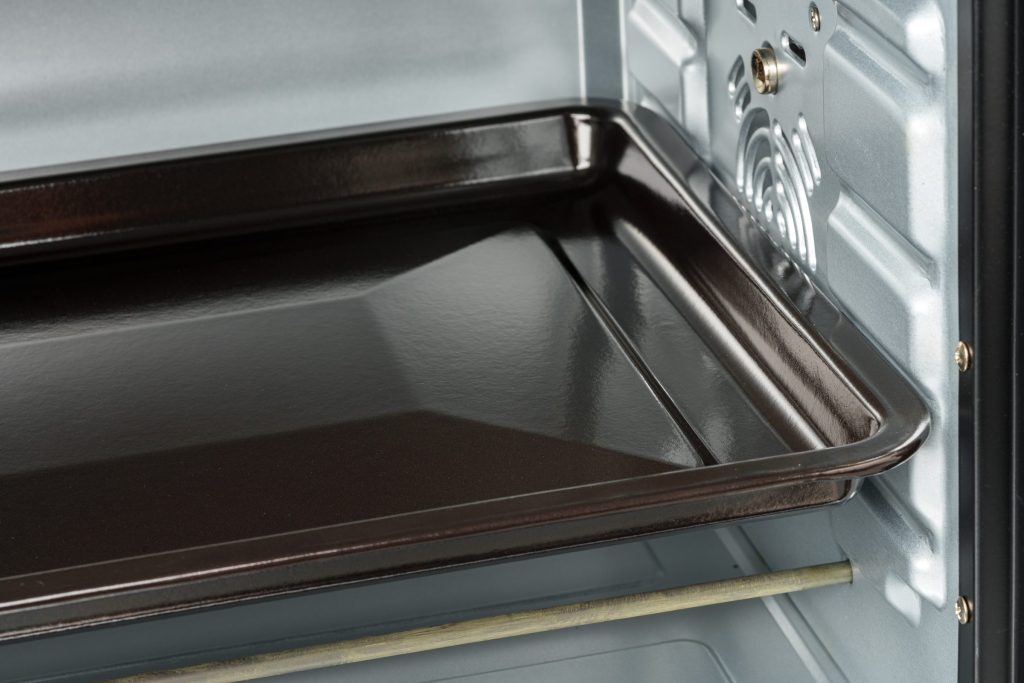 Empty oven interior with baking tray.