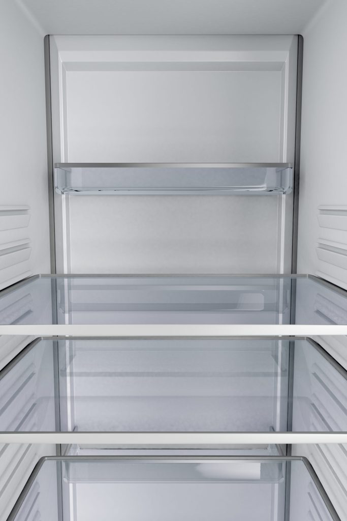 Empty refrigerator interior with shelves.