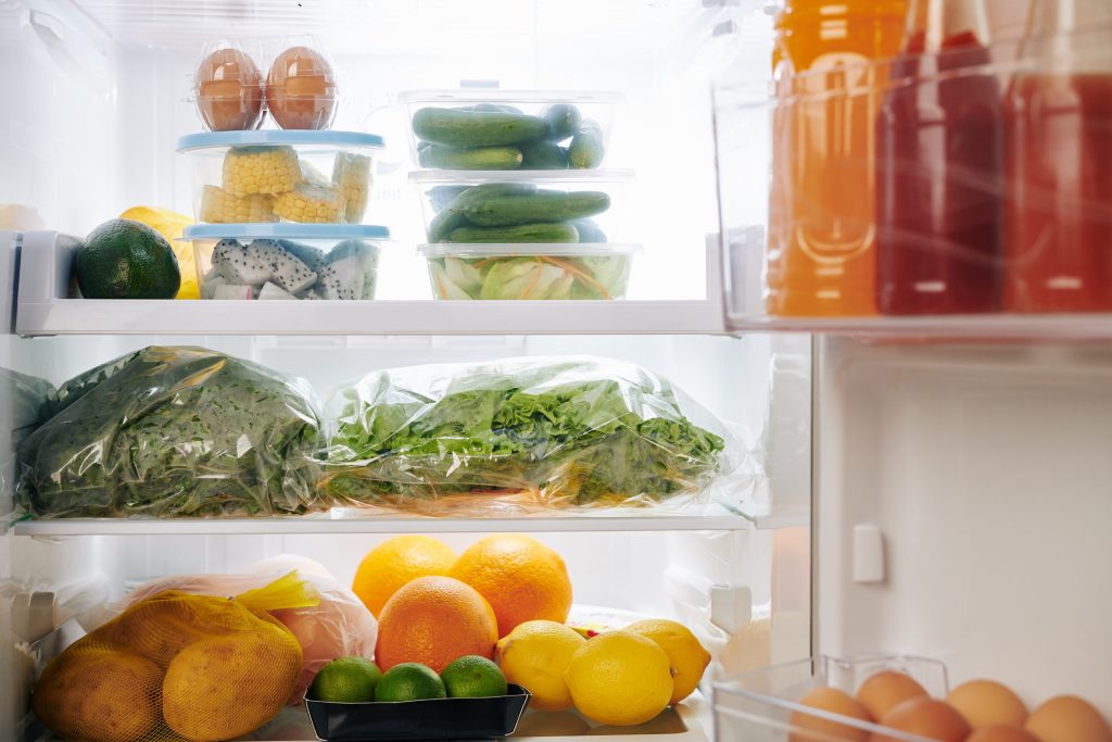 Fresh food inside a bright refrigerator.