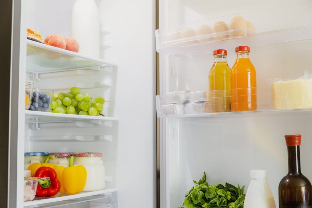 Fresh fruit and vegetables on the shelves of a refrigerator.