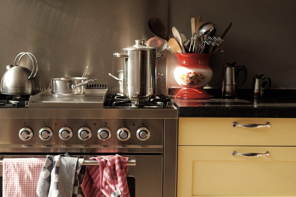 Kitchen utensils and cookware on stove top.