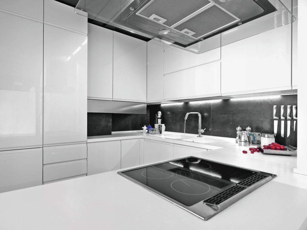 An oven in a modern kitchen design with sleek white cabinets.