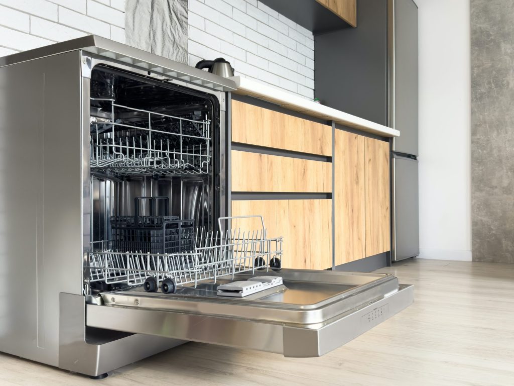 Modern kitchen dishwasher with open door.