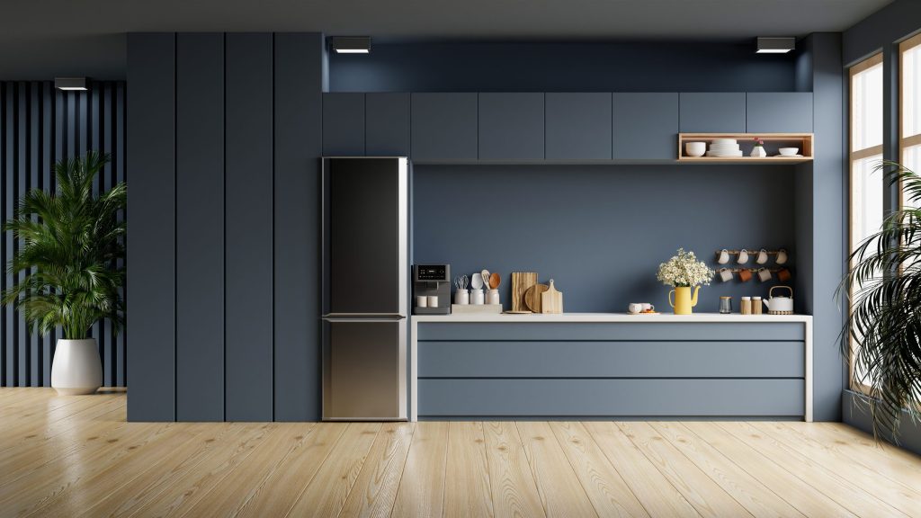An oven in a modern kitchen interior with blue cabinets.
