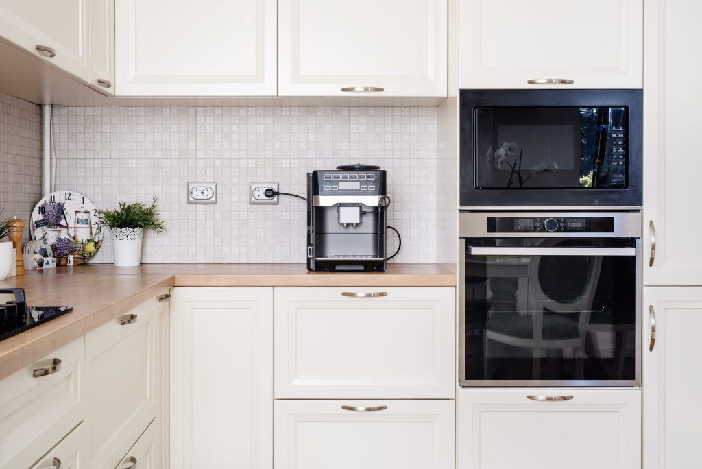 Modern kitchen interior with coffee maker and oven.