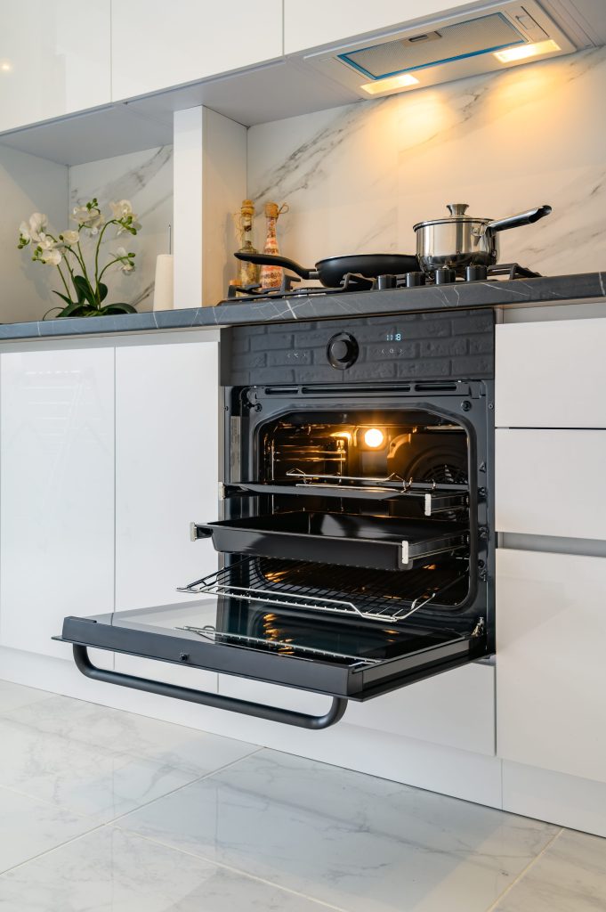 Modern kitchen with oven and cooking pans.