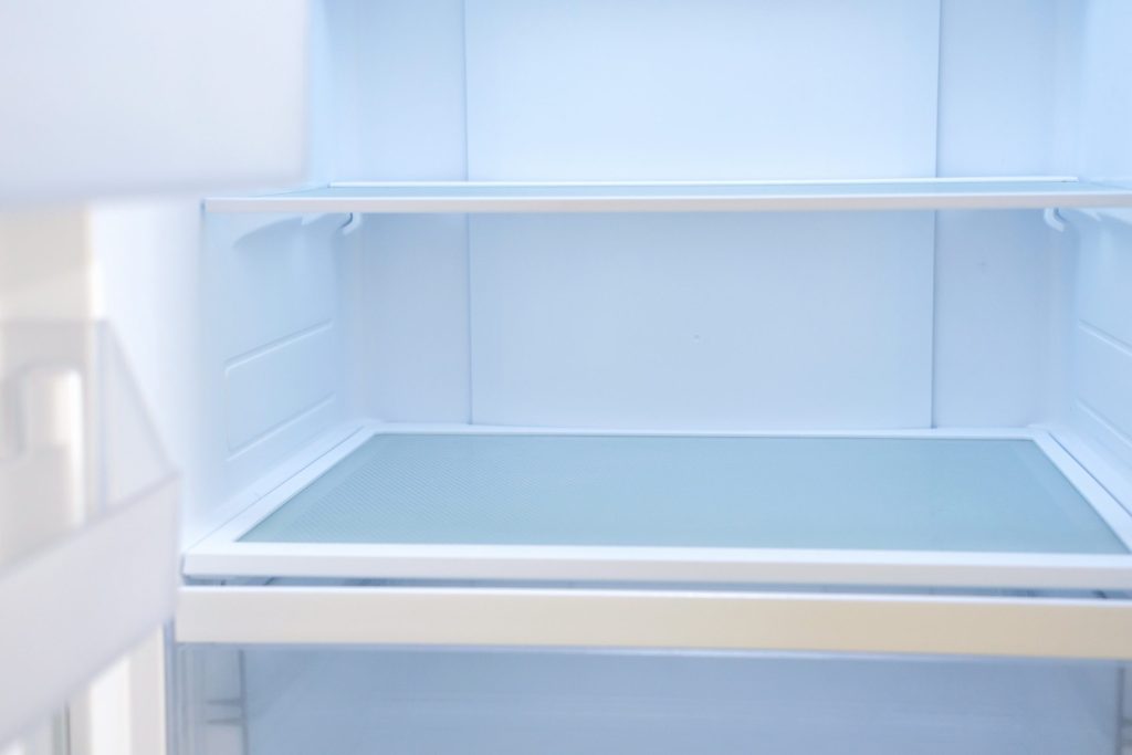 Modern white open refrigerator close up.