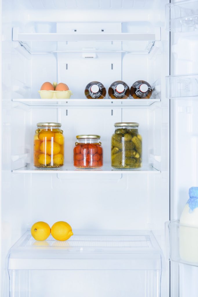 Organized refrigerator with pickles lemons.