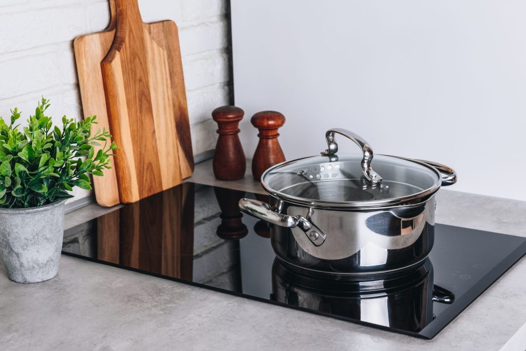 Pot on stove with cutting boards.
