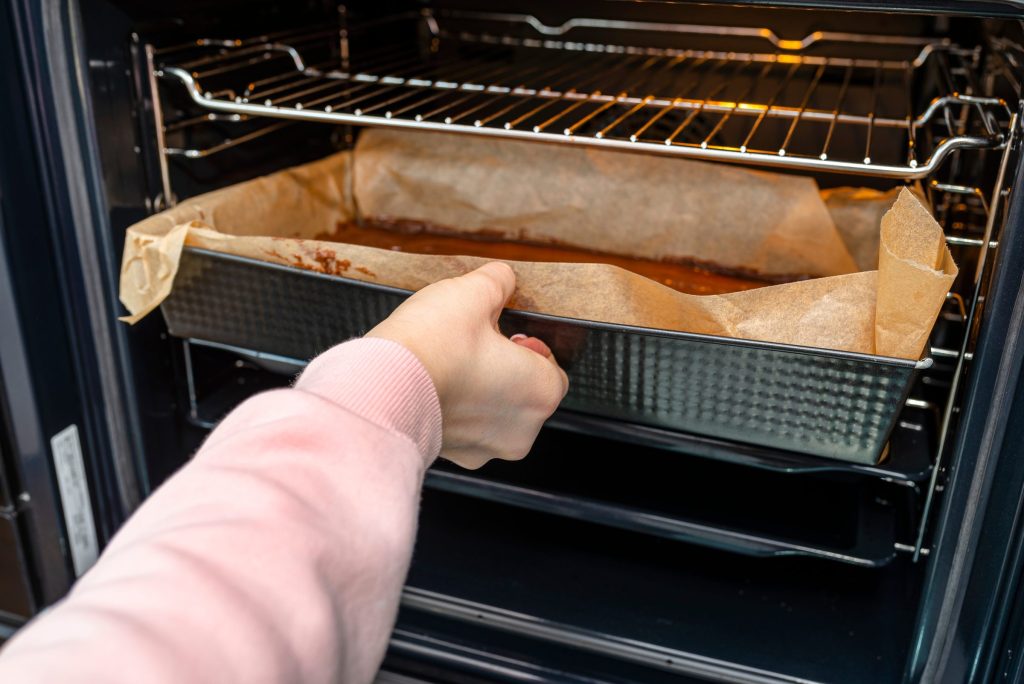 Preparing delicious dessert in oven at home.