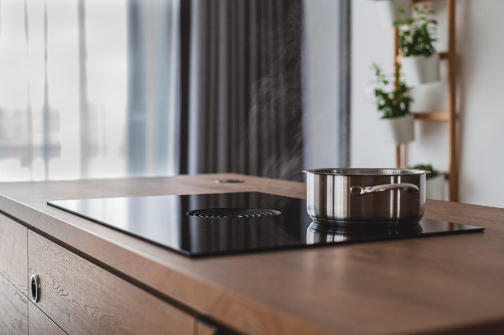 An oven in a steaming pot on modern kitchen counter.