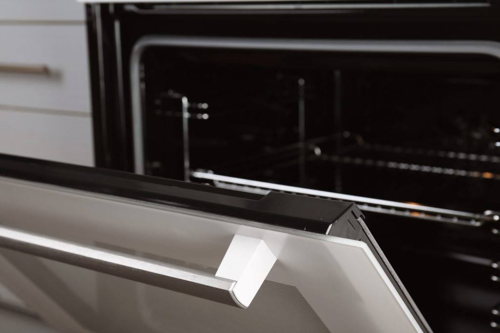 The door of a built-in oven standing ajar.