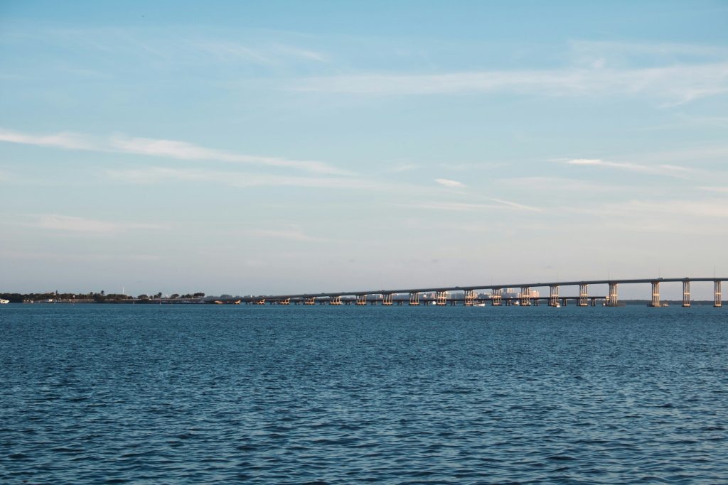 The Rickenbacker Causeway crossing Biscayne Bay under a clear sky, the low bridge running out across calm blue water toward Key Biscayne.