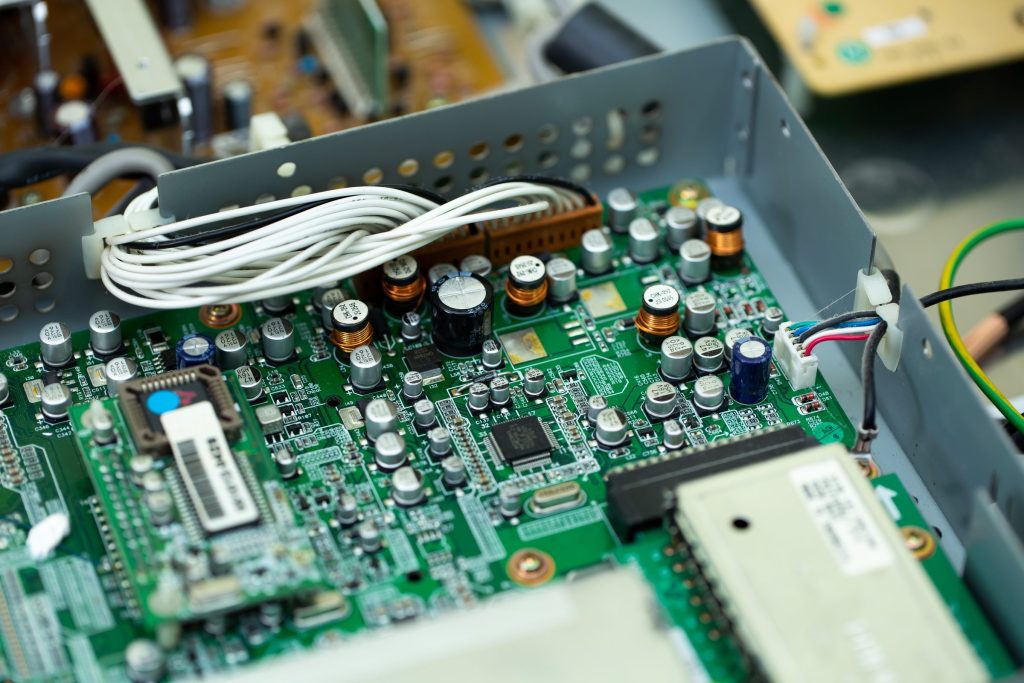 A board inside a steel chassis, wiring loom and connectors, a white service label at the left.